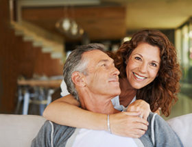 A very happy couple hugging on a sofa