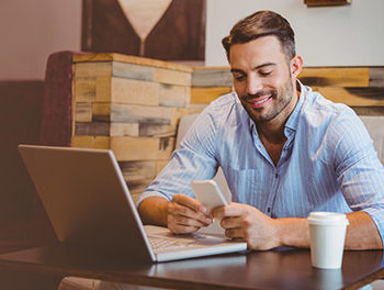 handsome man updating his online dating profile in a cafe