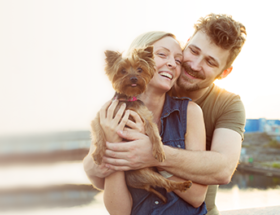 happy couple at the beach with their dog