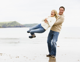 Ecstatic couple playing around at the beach