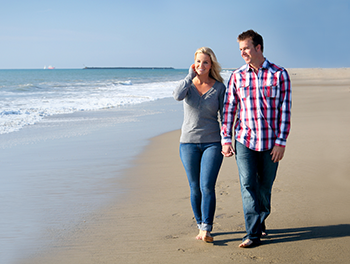 Couple on the beach walking hand in hand