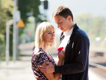 Couple having a sad goodbye hug in the street