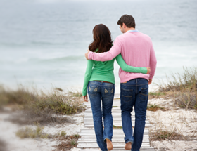 happy Kiwi couple walking on beach